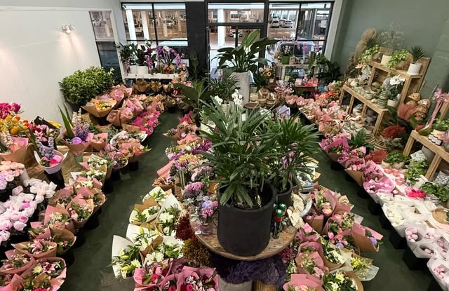 The Polyflora shop floor filled with wrapped bunches around a central palm